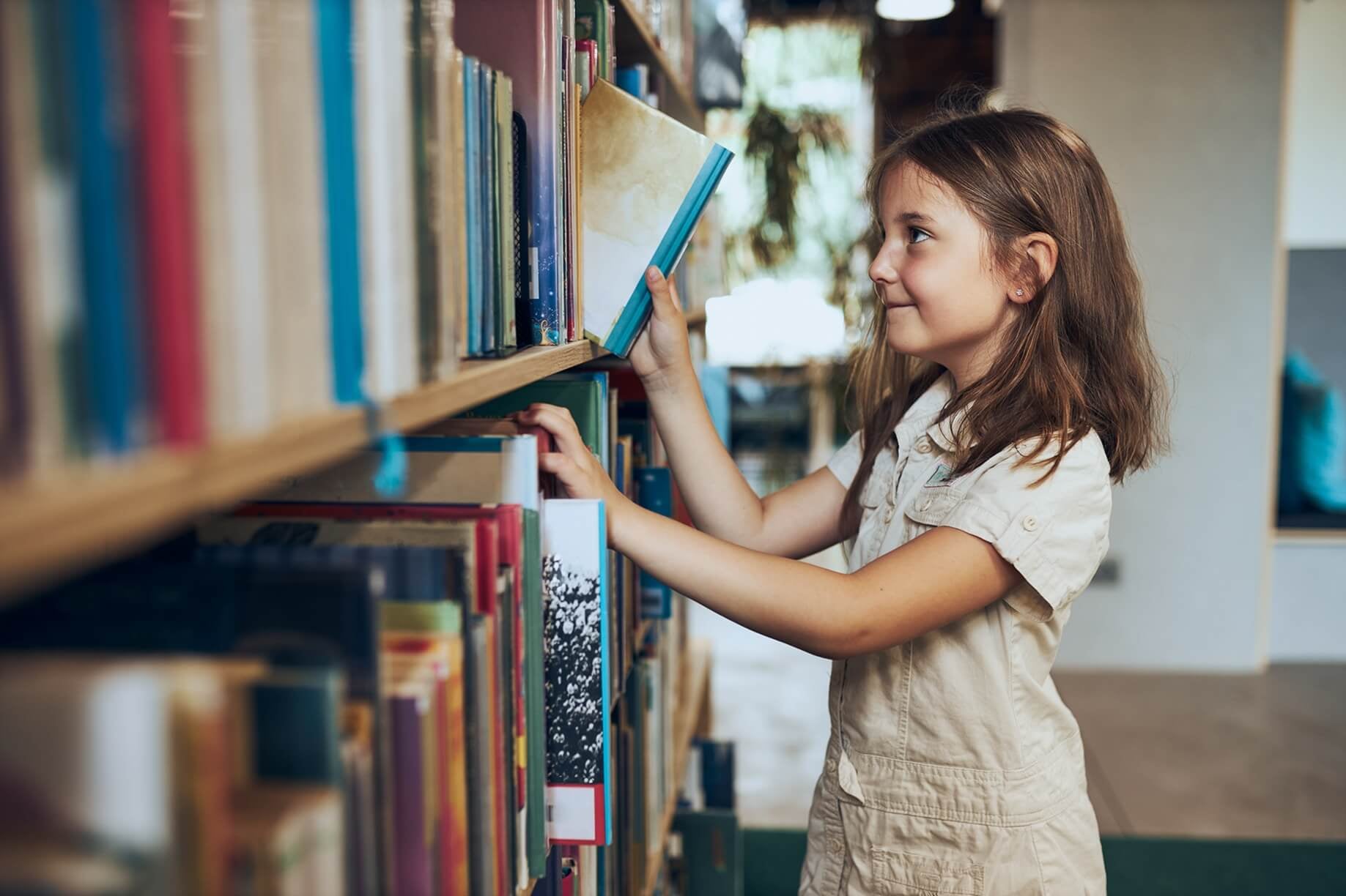 A girl choosing a book in the library.